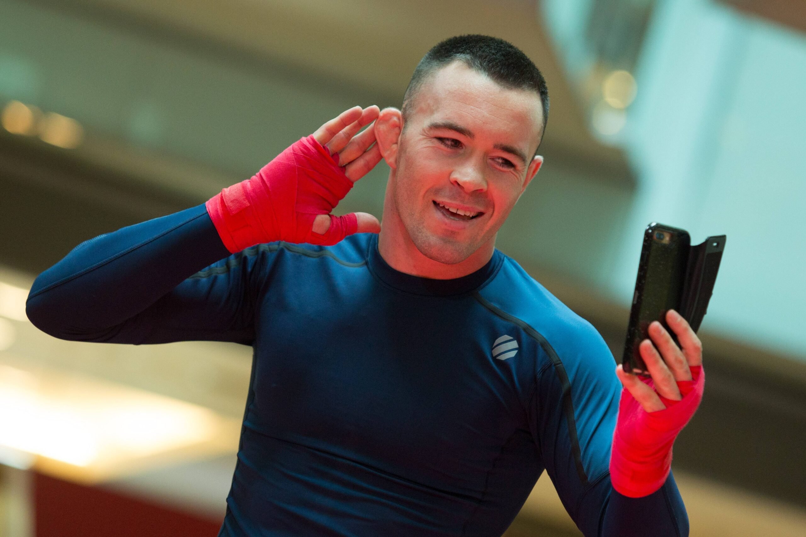 Colby Covington poses in front of a phone during his open workouts in 2017.