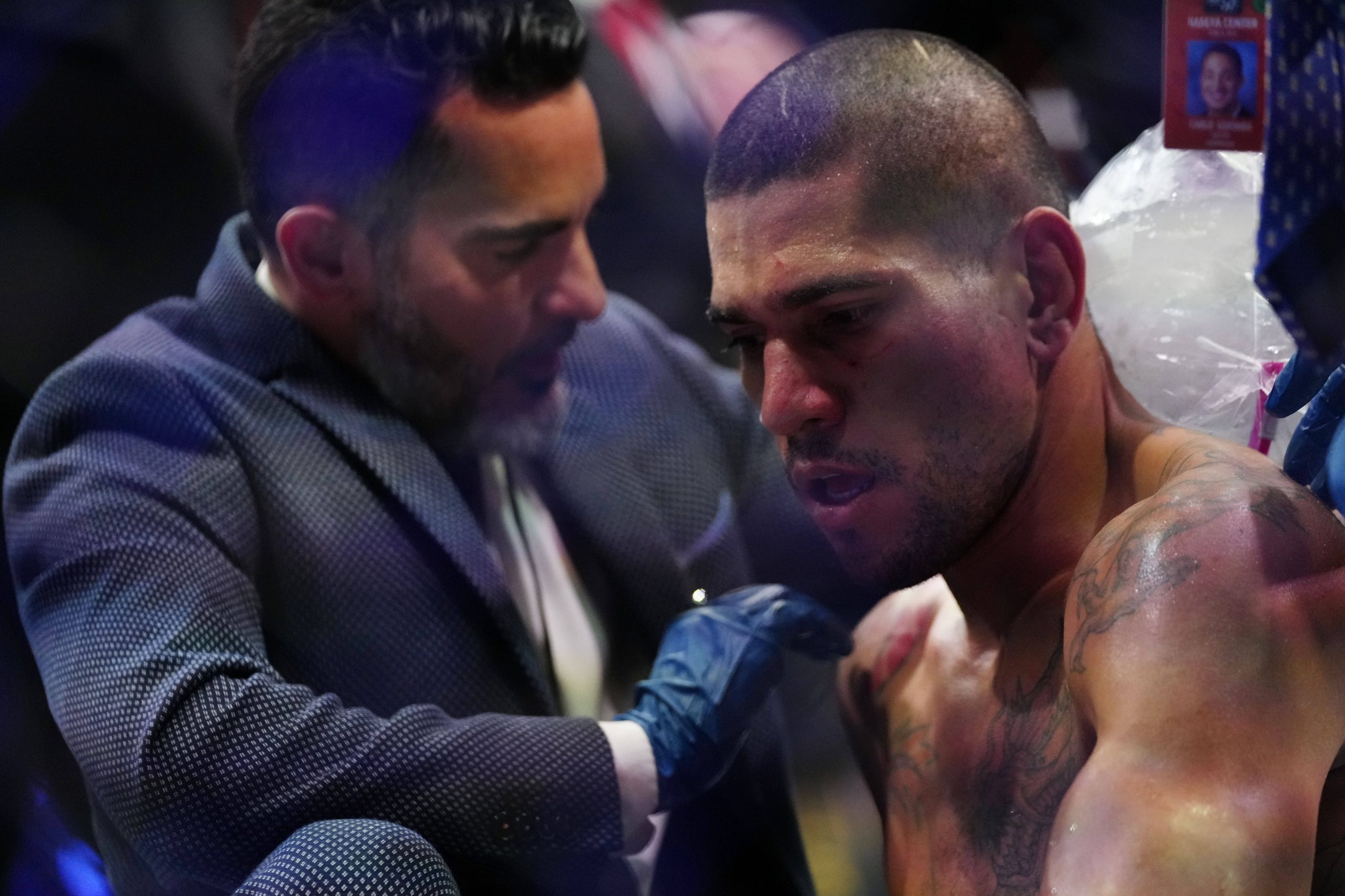 Alex Pereira (red gloves) is looked over by medical staff after the fight against Israel Adesanya (blue gloves) during UFC 287 at Miami-Dade Arena....