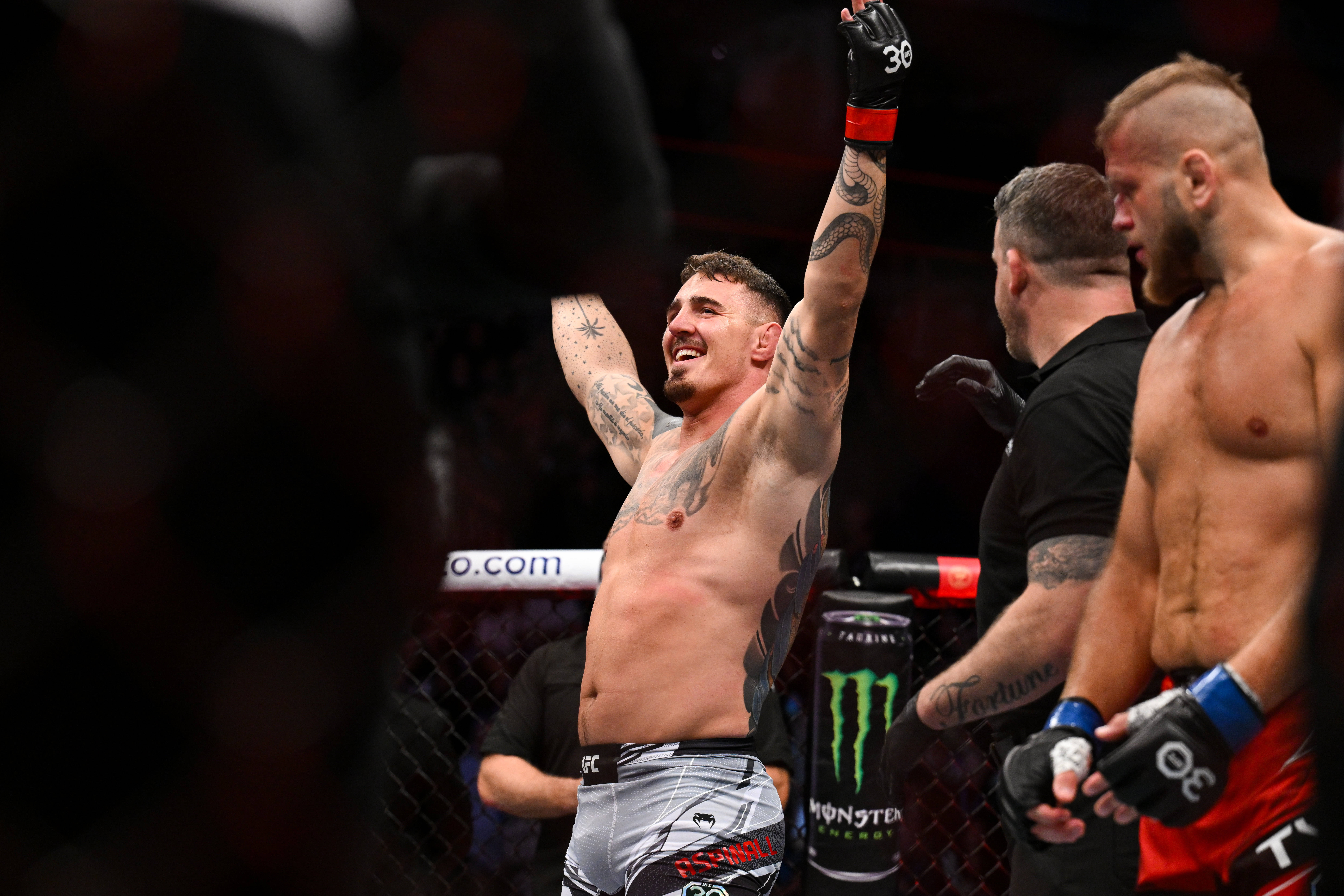 UFC 295's Tom Aspinall (red gloves) reacts to defeating Marcin Tybura (blue gloves) during UFC Fight Night at O2 Arena.
