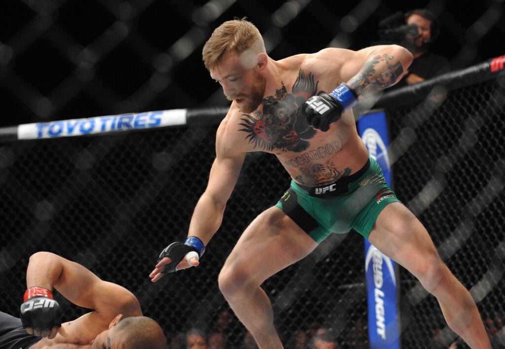Conor McGregor moves in to land punches and win via technical knockout against Jose Aldo during UFC 194