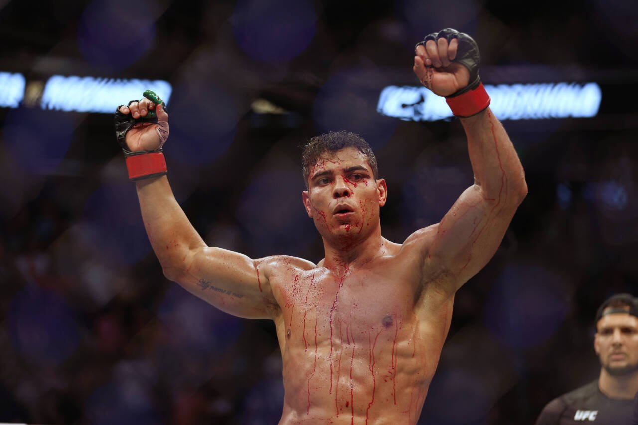 Paulo Costa (red gloves) reacts after defeating Luke Rockhold (blue gloves) during UFC 278 at Vivint Arena.