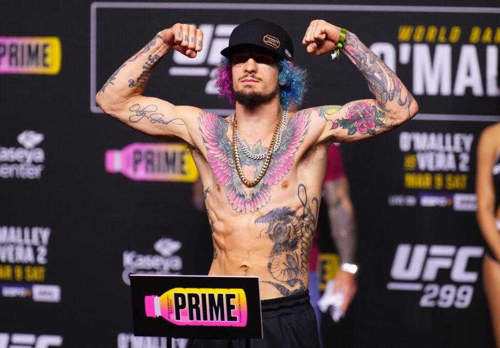 Sean O'Malley poses on the scales at the UFC 299 ceremonial weigh-ins