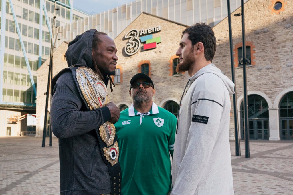 Jason Jackson, with his Bellator belt, faces off against Ramazan Kuramagomedov, with Mike Kogan standing between them