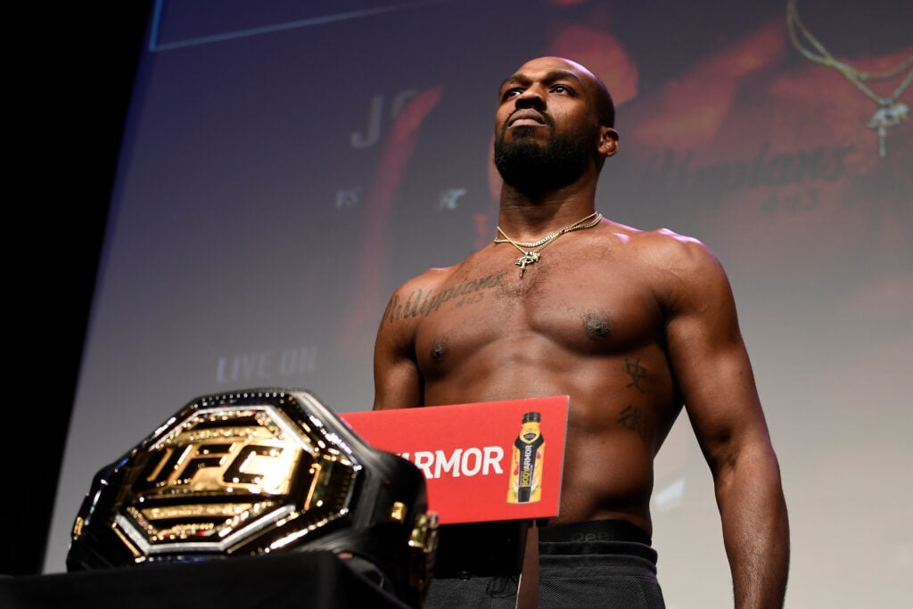 Jon Jones weighing in for a fight in front of his UFC title belt
