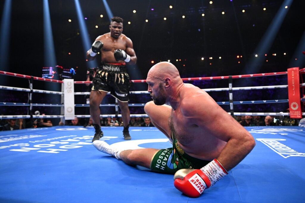 Francis Ngannou stands over Tyson Fury after dropping him in their boxing fight