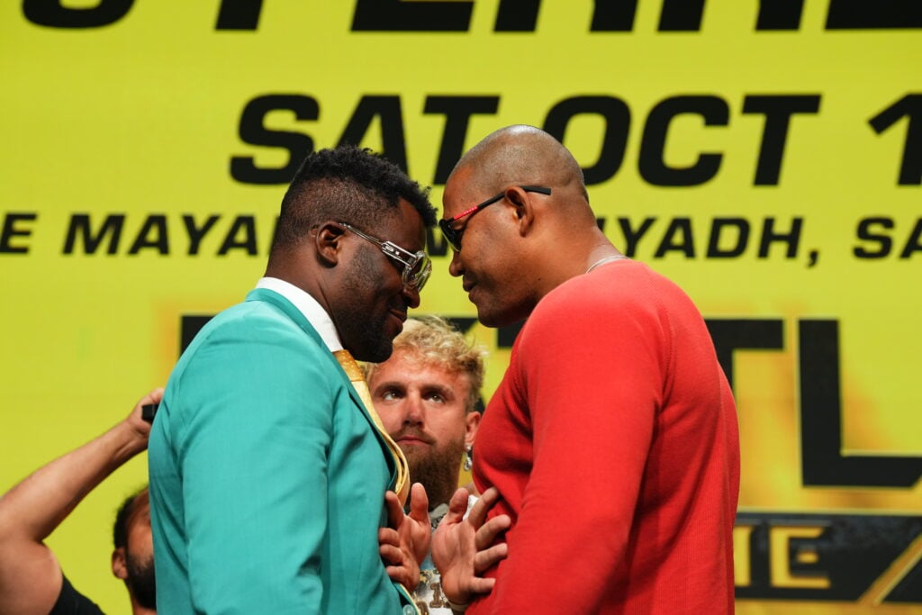 Francis Ngannou facing off with Renan Ferreira with Jake Paul standing between them