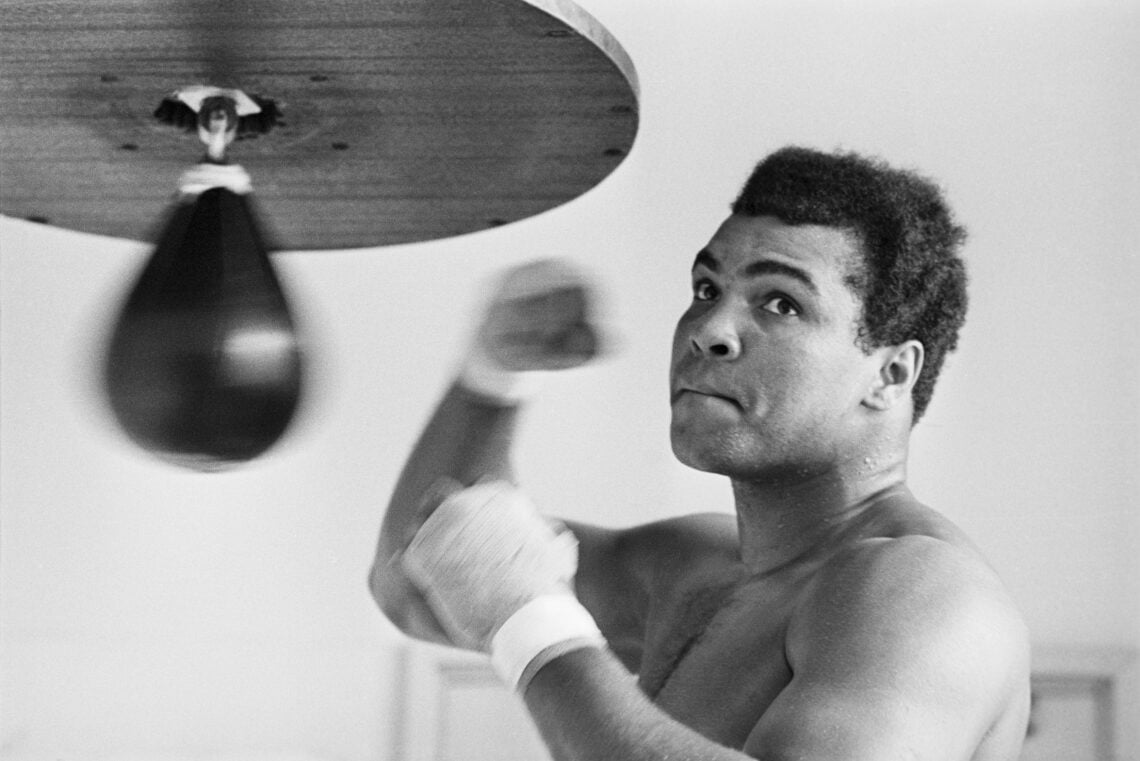 (Original Caption) Caught in a rare pose- his mouth shut--Muhammad Ali punches bag here March 31 (Tokyo Time) for his April 1 bout with heavyweight...