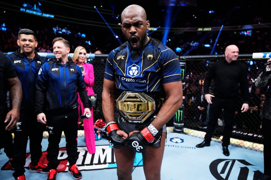Jon Jones flexes with the UFC title