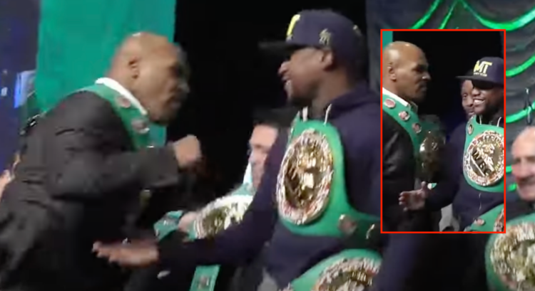 Mike Tyson swings a punch at Floyd Mayweather