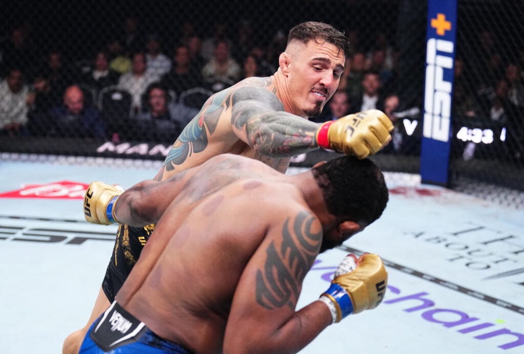 Tom Aspinall punches Curtis Blaydes during their title fight at UFC 304