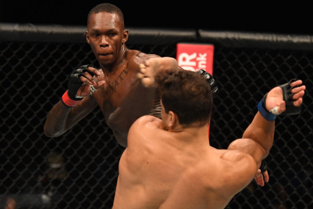 Israel Adesanya lands a head kick on Paulo Costa during UFC 253 title fight