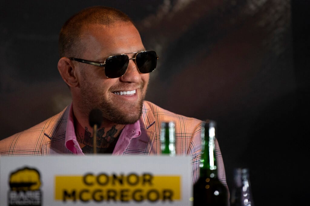 Conor McGregor smiles on stage at a BKFC press conference in Marbella