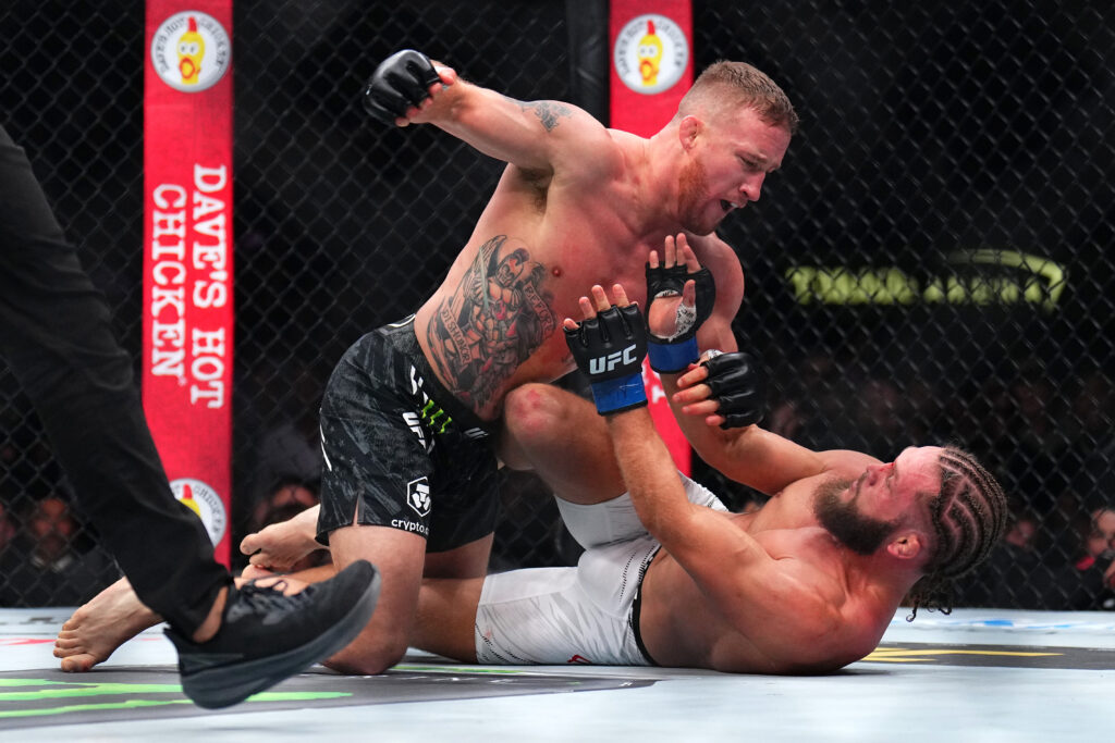 Justin Gaethje punches Rafael Fiziev during a grappling exchange at UFC 313.