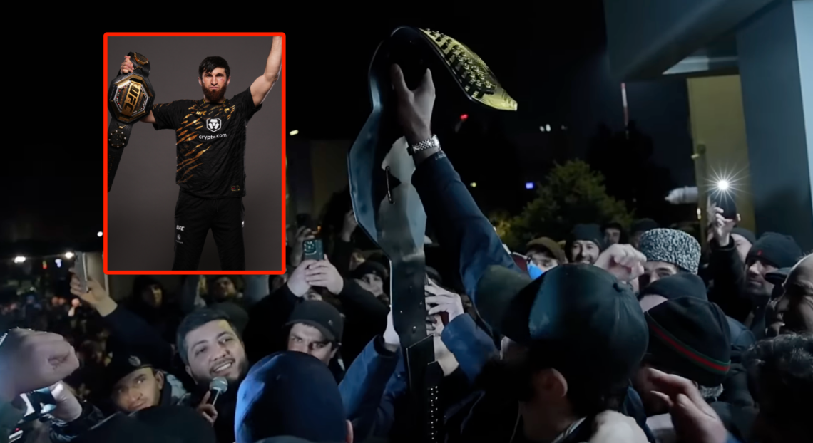 Magomed Ankalaev holding his UFC title belt aloft at his homecoming in front of a large crowd, with a block showing him doing the same face-on