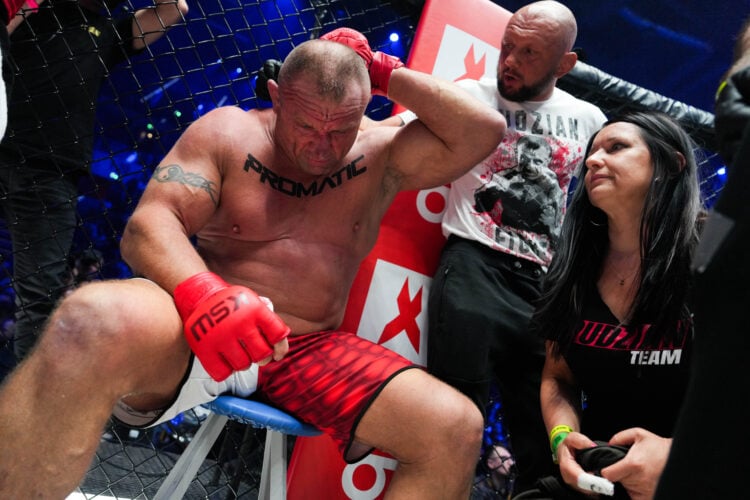 Image of Mariusz Pudzianowski holding the back of his head after being KO'd by Eddie Hall