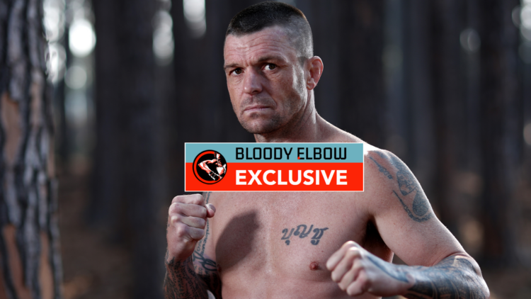John Wayne Parr posing for a photoshoot with exclusive banner