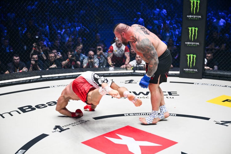 Eddie Hall stands over Mariusz Pudzianowski during their KSW fight