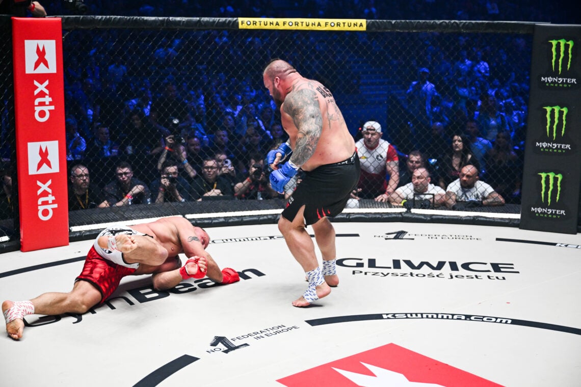 Eddie Hall stands over Mariusz Pudzianowski during their KSW fight