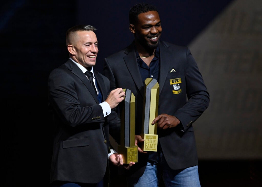 Georges St-Pierre and Jon Jones hold up their awards during the UFC Hall of Fame Class of 2020 Induction Ceremony