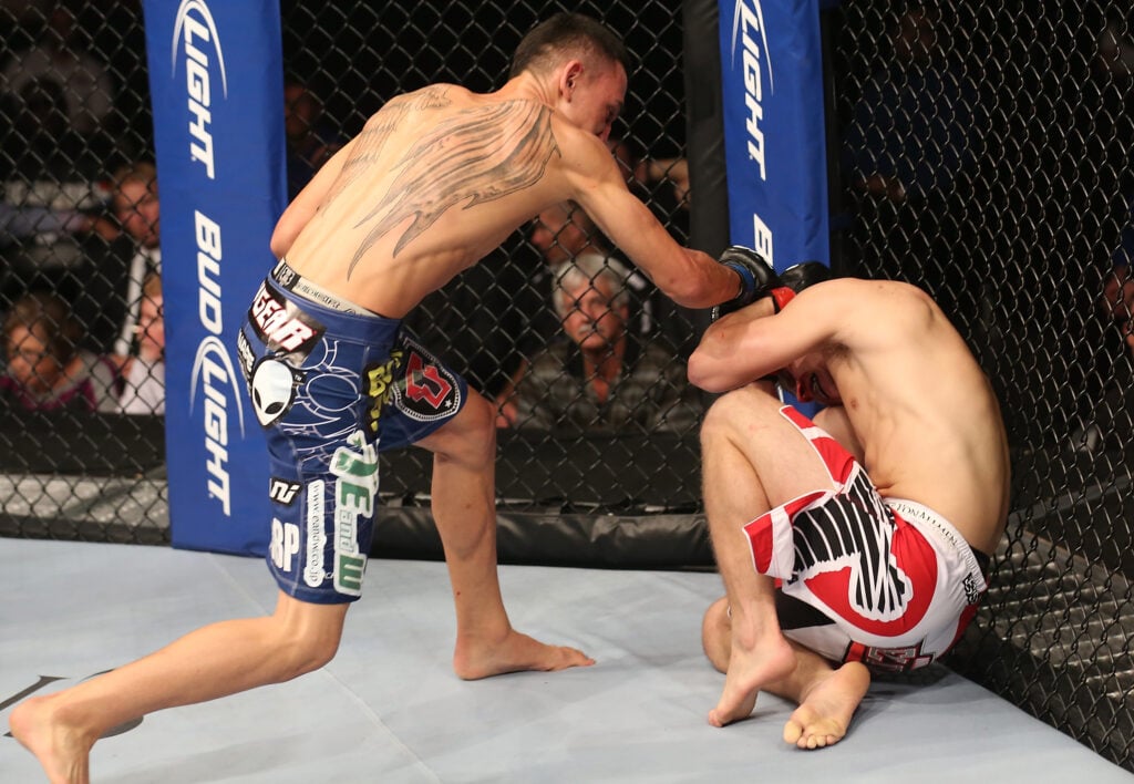 Max Holloway punches Justin Lawrence during their fight at UFC 150
