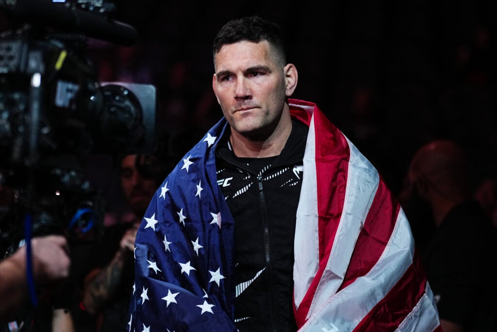 Chris Weidman walks to the cage with an American flag around his shoulders