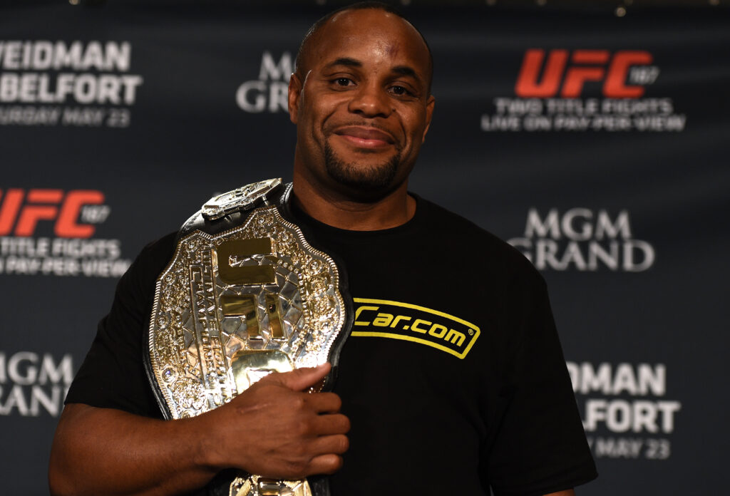 Даниэль Кормье позирует с титулом UFC после боя на UFC 187