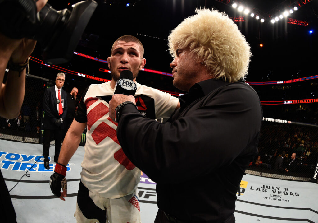 Joe Rogan wearing a papakha interviews Khabib Nurmagomedov after a UFC fight