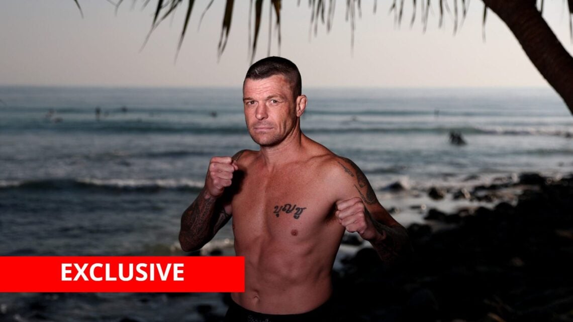 John Wayne Parr poses by the sea with exclusive banner