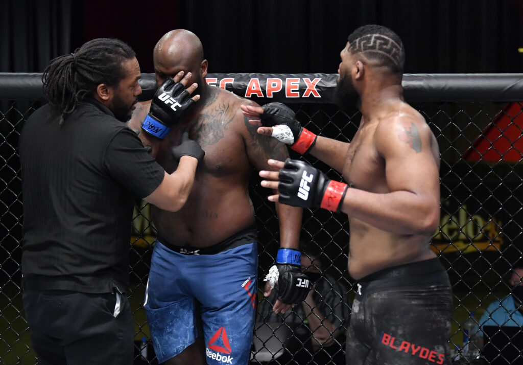 Herb Dean checks on Derrick Lewis after Curtis Blaydes poked him in the eye