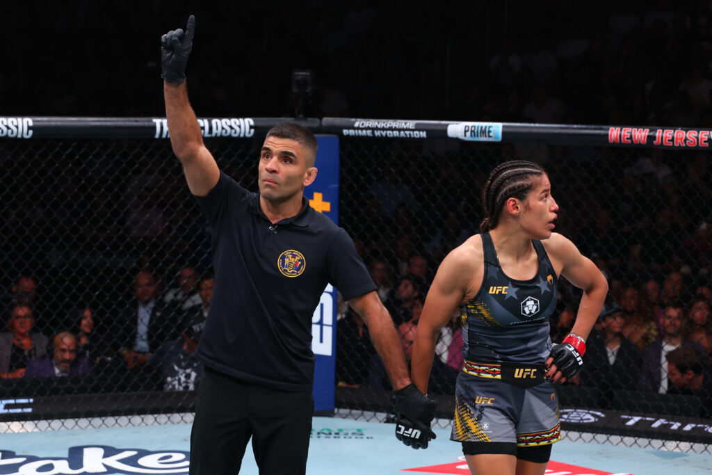 Referee Vitor Ribeiro takes a point for an illegal kick by Julianna Pena against Kayla Harrison