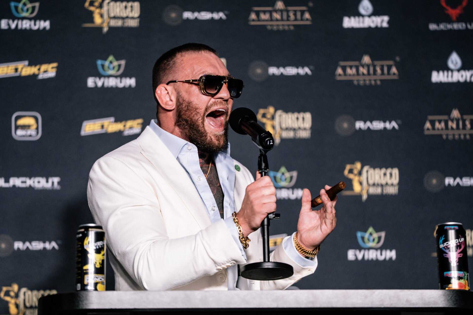 Conor McGregor shouting into a microphone at a BKFC press conference