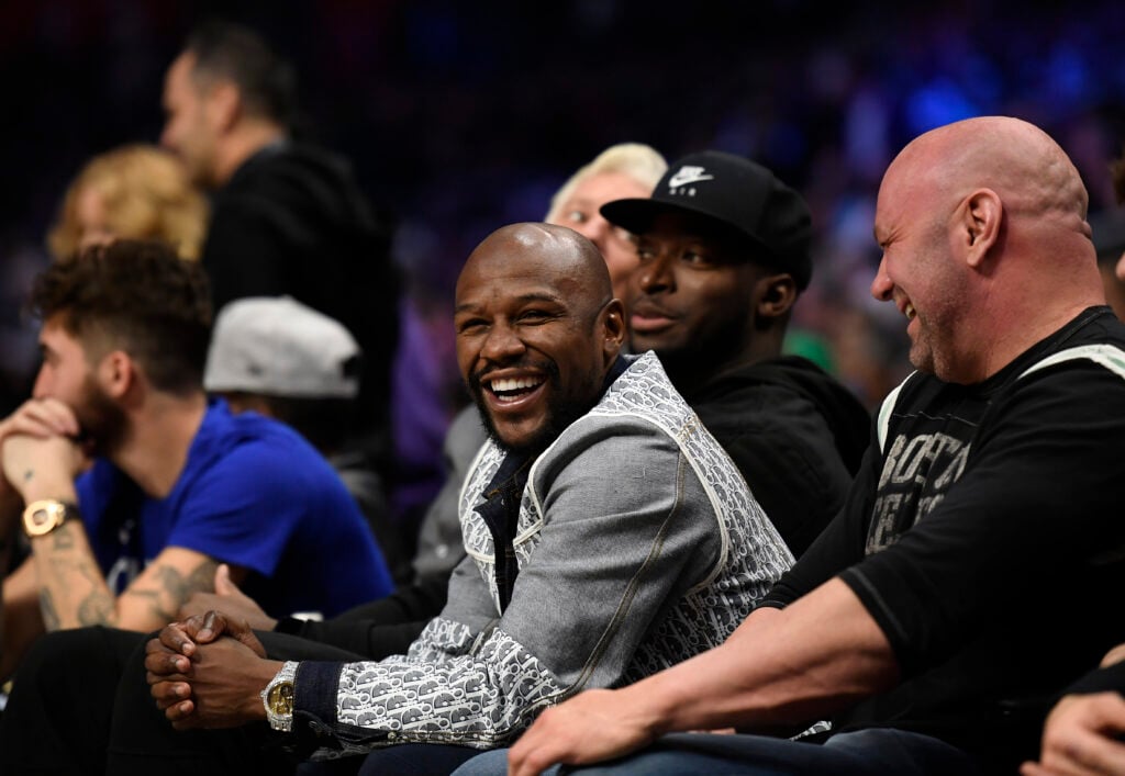 Floyd Mayweather and Dana White laughing together at an NBA game