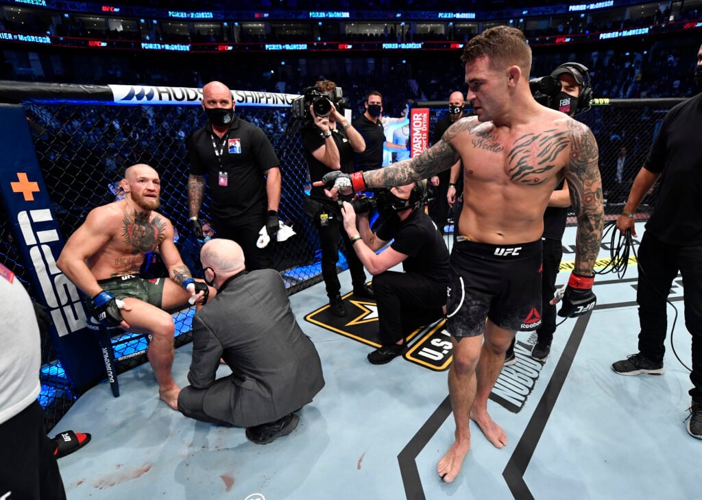 Dustin Poirier interacts with Conor McGregor after knocking him out in their fight at UFC 257.