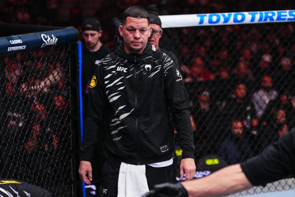 Nate Diaz walks into the octagon in Kron Gracie's corner at UFC 310