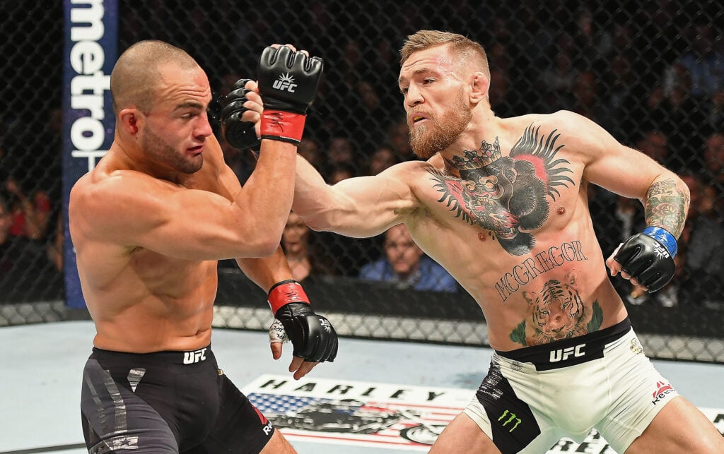 Conor McGregor punches Eddie Alvarez during their title fight at UFC 205