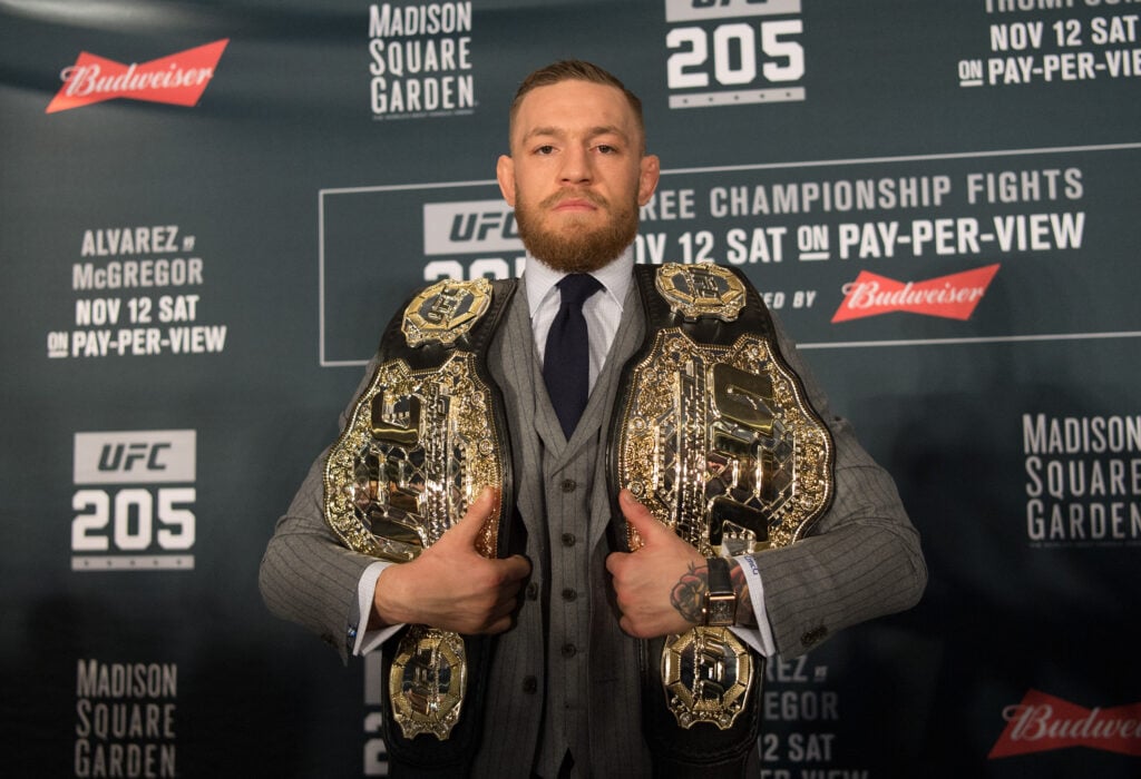 Conor McGregor holding two belts at UFC 205