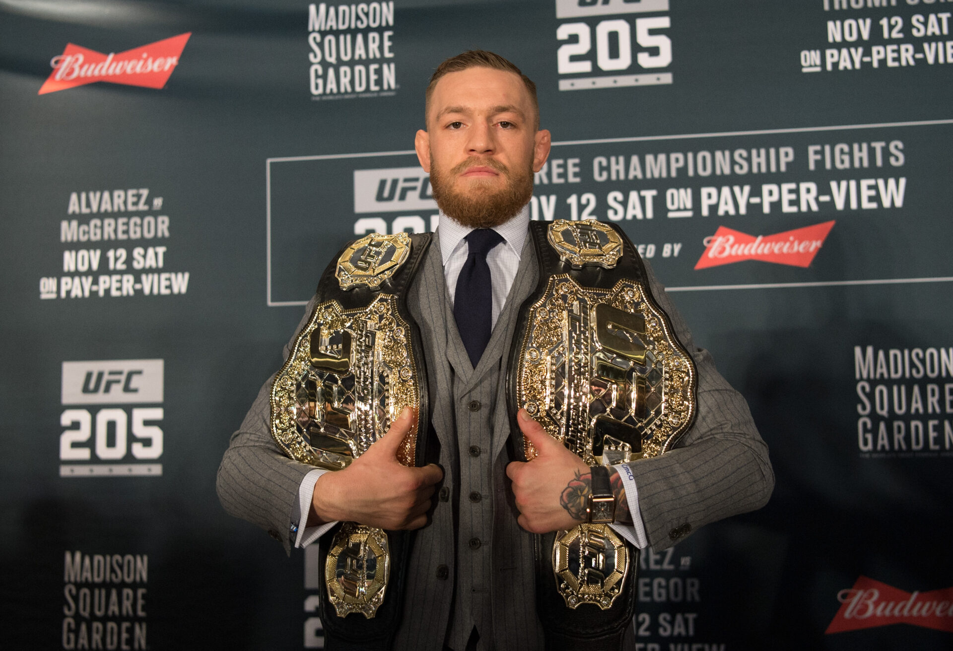 Conor McGregor holding two belts at UFC 205