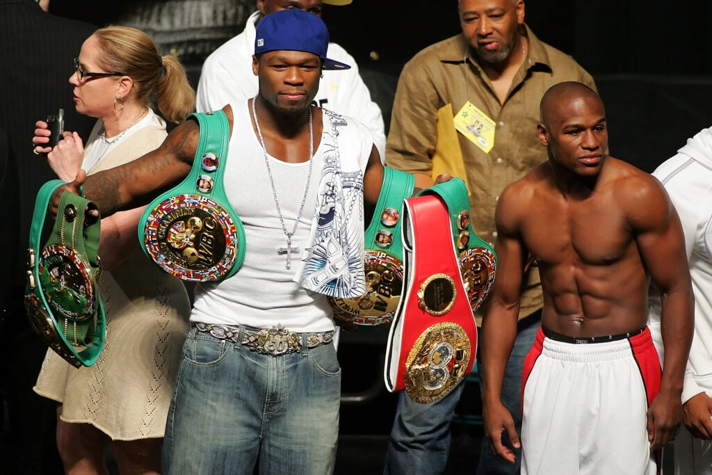 50 Cent holds Floyd Mayweather's belts at the Oscar De La Hoya weigh-in