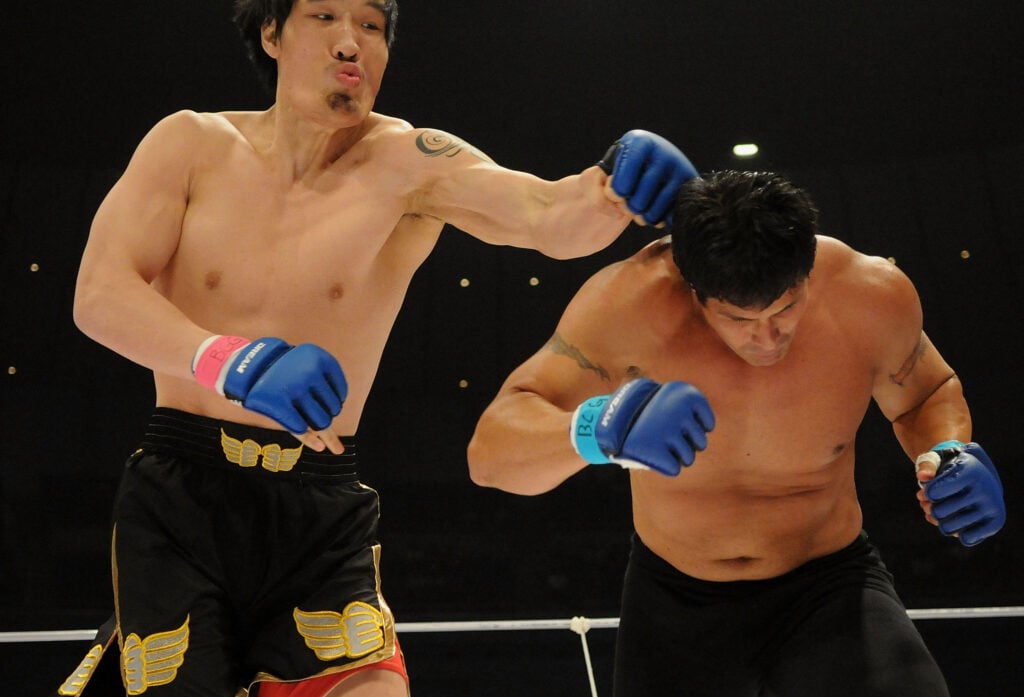 Hongman Choi hits Jose Cansesco on the back of the head during their fight