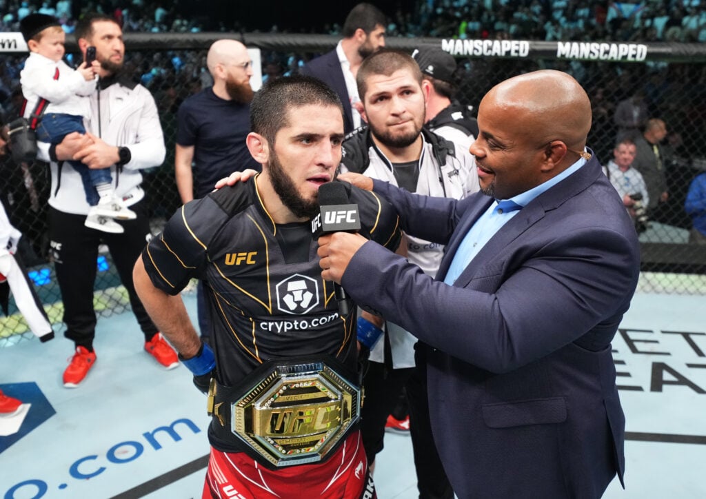 Islam Makhachev is interviewed alongside Khabib Nurmagomedov inside the cage after beating Charles Oliveira in their title fight at UFC 280.