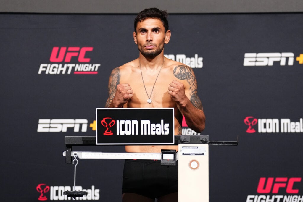 Alex Perez poses on the scales at the UFC weigh in
