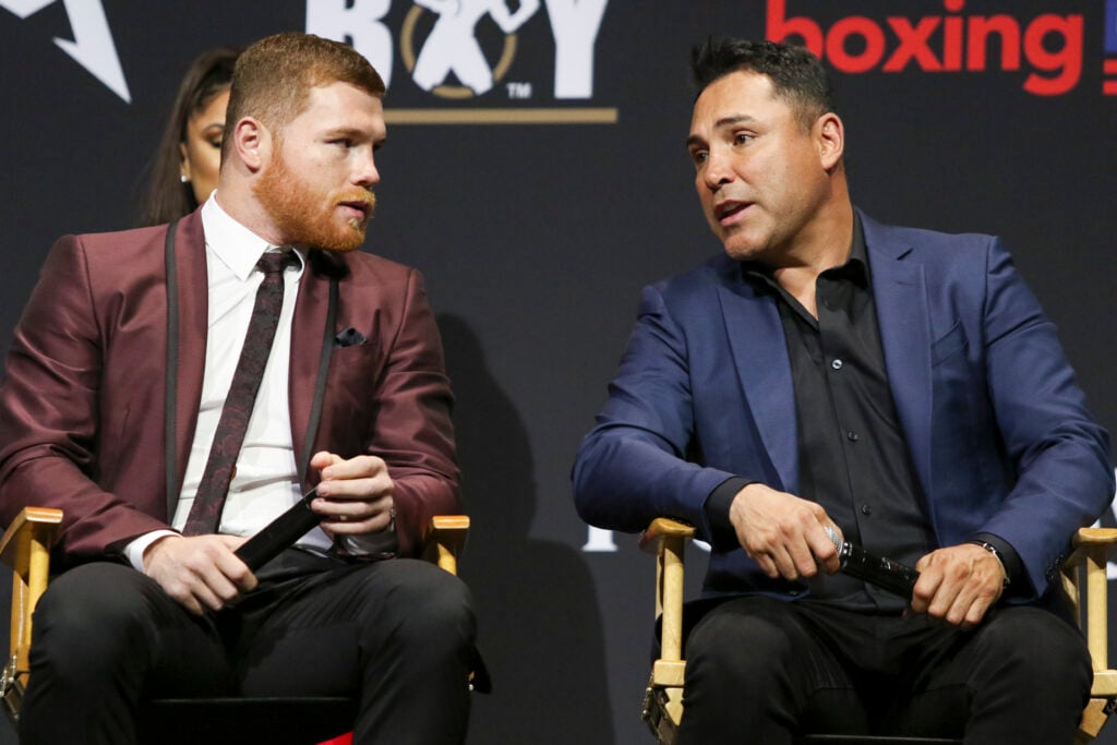 Canelo Alvarez (L) and Oscar De La Hoya (R) interact during a press conference to promote his WBC, WBA, and IBF middleweight unification fight versus Daniel Jacobs