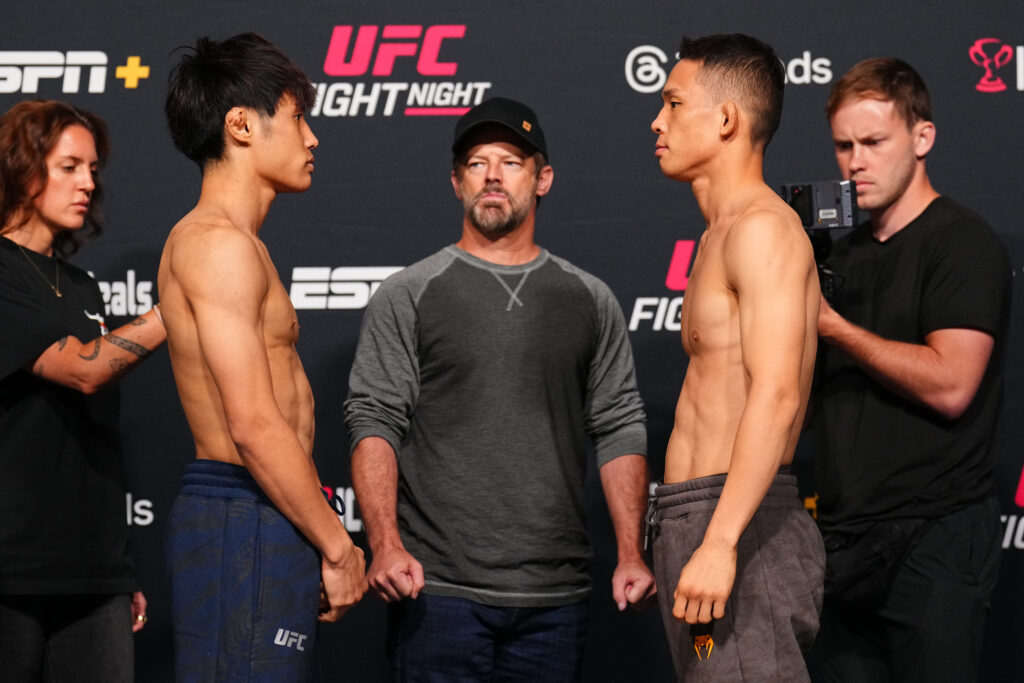 Tatsuro Taira and Hyun Sung Park face off with a man inbetween them and security either side