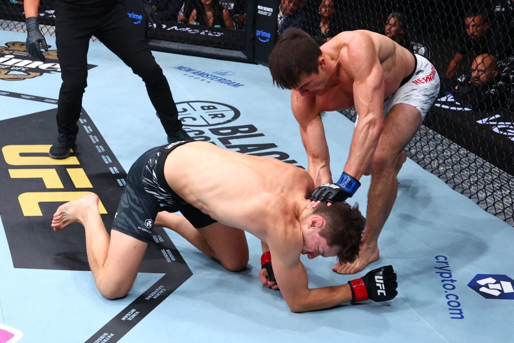 Alexander Hernandez punches a grounded Chase Hooper during their fight at UFC 319