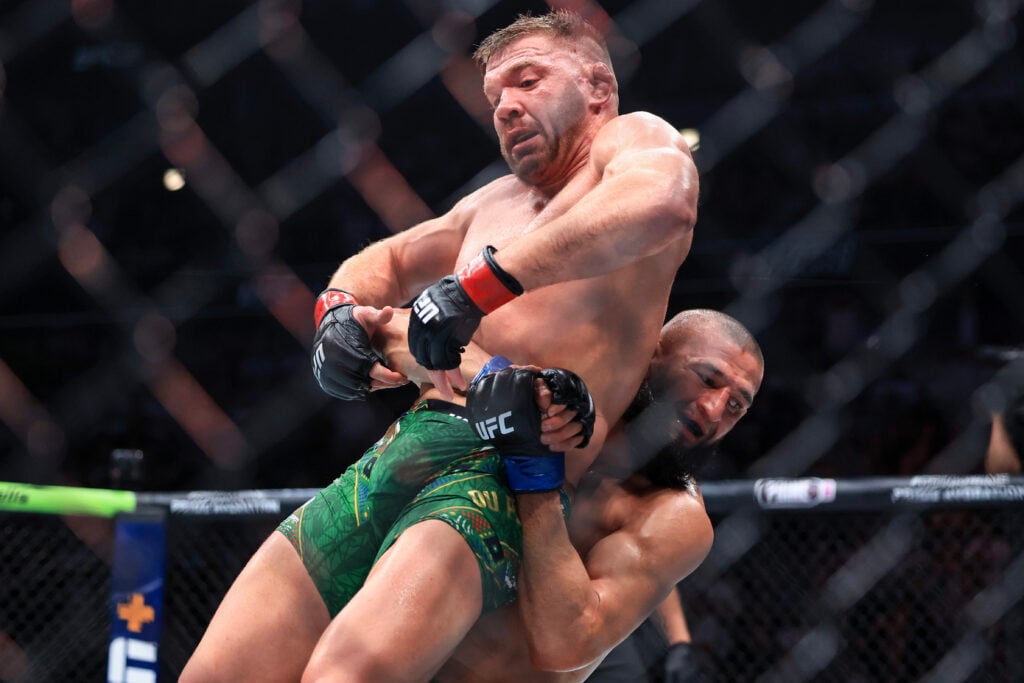 Khamzat Chimaev lifts and throws Dricus du Plessis during their title fight at UFC 319