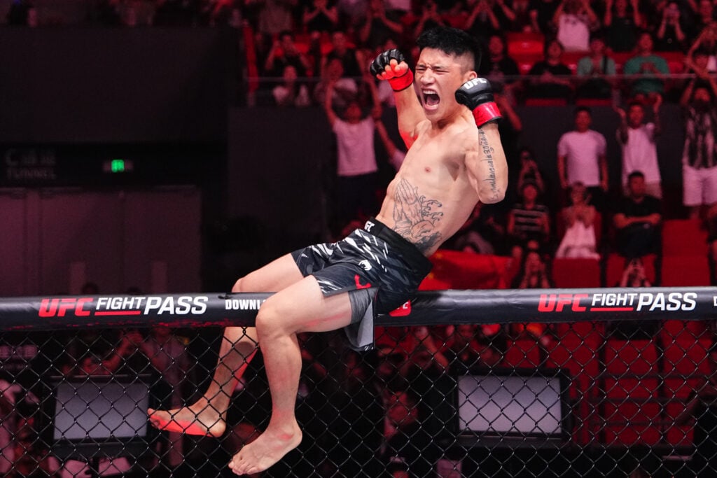 Yizha celebrates on top of the cage after knocking out Westin Wilson in their fight at UFC Shanghai