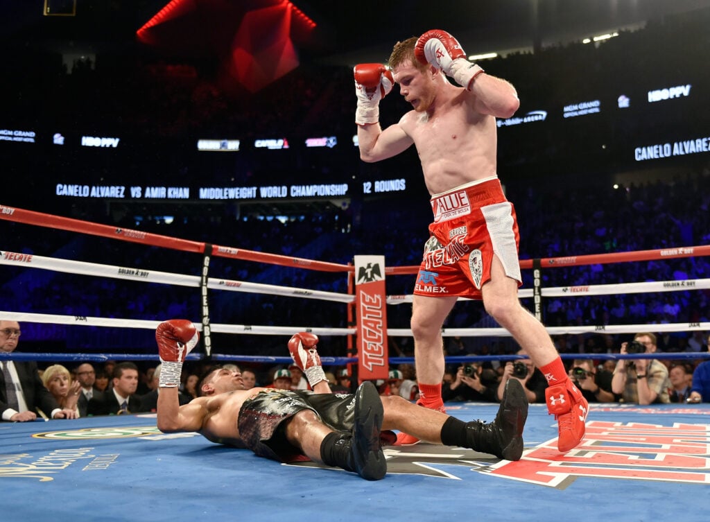 Canelo Alvarez stands over Amir Khan after knocking him out