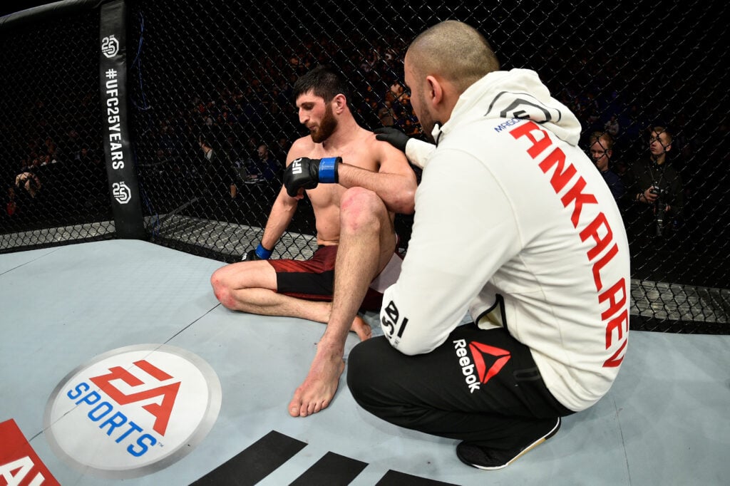 Magomed Ankalaev sats in the octagon with his coach after losing to Paul Craig