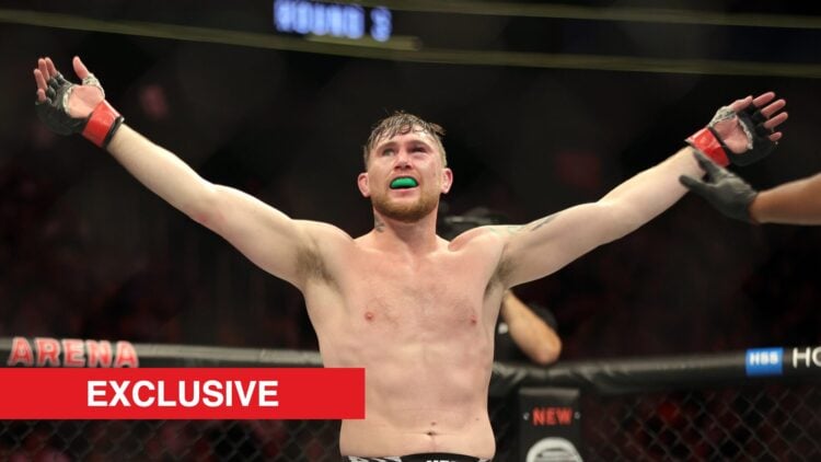 Darren Till raises his arms in the octagon during a fight