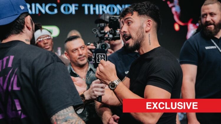 Warren Spencer in a black t-shirt speaks to Dillon Danis, in a blue snapback, at their pre-fight press conferece